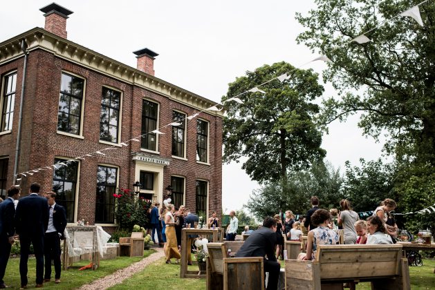 Foto van feest in de voortuin van een bijzonder gebouw