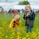 Foto met kinderen in een geel bloemenveld