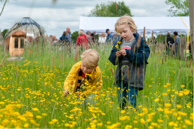 Foto met kinderen in een geel bloemenveld